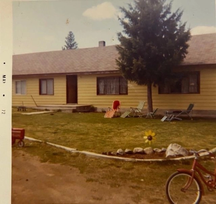 A yellow house with a bicycle parked in front of it.